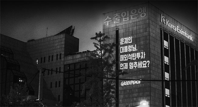 국제환경단체 그린피스가 지난해 6월 한국수출입은행 건물 외벽에 해외 석탄 투자 중단 촉구 메시지를 레이저빔으로 쏘고 있다. ⓒphoto 그린피스