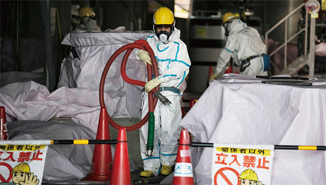 후쿠시마 오염수 저장탱크에서 호스를 옮기고 있는 작업자들. ⓒphoto 뉴시스