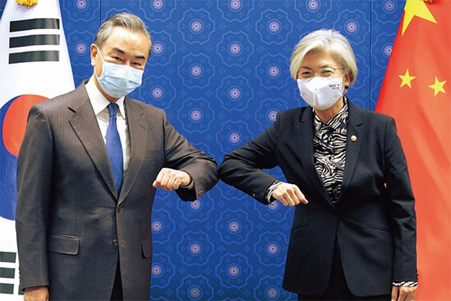 지난 11월 26일 강경화 외교장관이 방한한 왕이 중국 외교부장(왼쪽)과 팔꿈치를 맞대면서 인사하고 있다. ⓒphoto 외교부