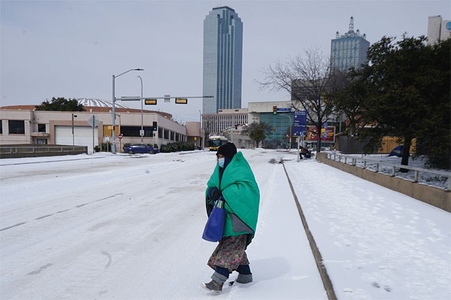 지난 2월 한파가 덮친 미국 텍사스주 댈러스에서 한 시민이 담요를 뒤집어쓴 채 거리를 걷고 있다. ⓒphoto 뉴시스