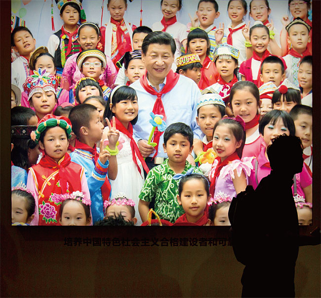 아이들에 둘러싸여 있는 시진핑 주석의 모습이 떠 있는 베이징 거리의 한 전광판. ⓒphoto  뉴시스