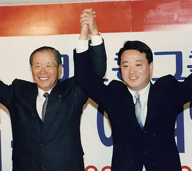 1996년 1월 29일 코오롱그룹 회장 이취임식에서 이동찬 선대회장(왼쪽)이 이웅열 명예회장의 손을 들어주고 있다. ⓒphoto 코오롱그룹