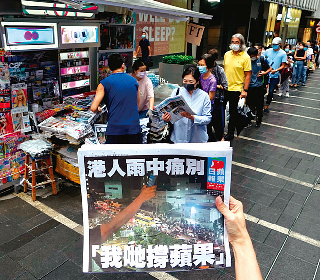 지난 6월 24일 비가 오는 가운데 이날 폐간되는 마지막 빈과일보를 사려는 홍콩 시민들이 가판대 앞에 줄을 길게 서 있다. 이날 빈과일보 1면 제목은 ‘홍콩인은 빗속에서 아프게 이별한다’였다. ⓒphoto 뉴시스