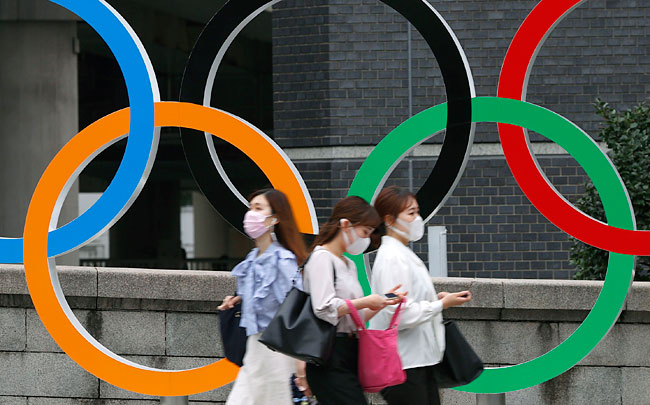 일본의 수도이자 2020 도쿄올림픽 개최지인 도쿄도는 12일부터 다음 달 22일까지 코로나19 관련 4번째 긴급사태를 선포했다. 이에 따라 23일 개막하는 도쿄올림픽은 긴급사태 선언 아래 치러진다. 지난 8일 일본 도쿄에서 코로나19 확산 방지를 위해 마스크를 쓴 사람들이 도쿄 올림픽 오륜 조형물 앞을 지나가고 있다. ⓒphoto.뉴시스