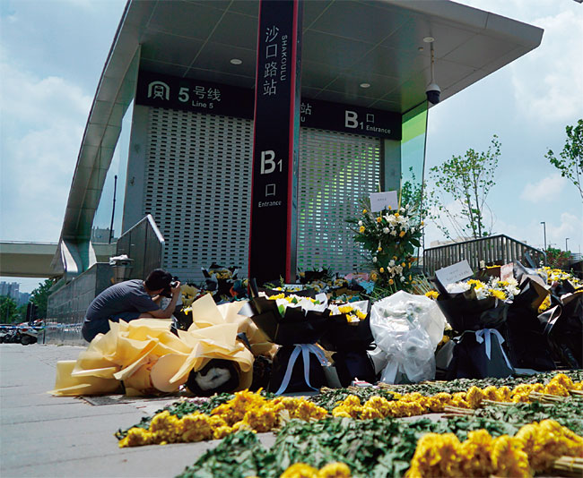 최근 중국 허난성 중부에 내린 기록적 폭우로 수많은 사상자가 나온 가운데 지난 7월 27일 정저우의 한 지하철역 입구 앞에 주민들이 갖다놓은 추모 꽃다발이 놓여 있다. ⓒphoto 뉴시스