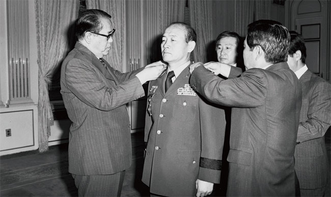 1980년 8월 전두환 당시 국보위 상임위원장(가운데)에게 육군 대장 계급장을 수여하는 최규하 당시 대통령(왼쪽). ⓒphoto 정부기록사진집