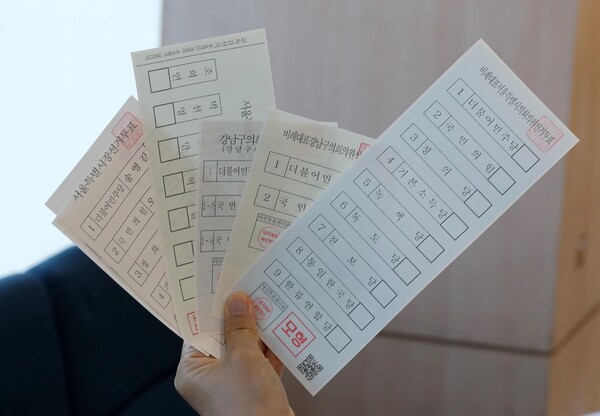 제8회 전국동시지방선거 사전투표를 하루 앞둔 5월 26일, 서울 강남구 대치4동주민센터에 설치된 대치4동 사전투표소에서 투표소 관계자가 모의투표용지를 살펴보고 있다. photo 뉴시스