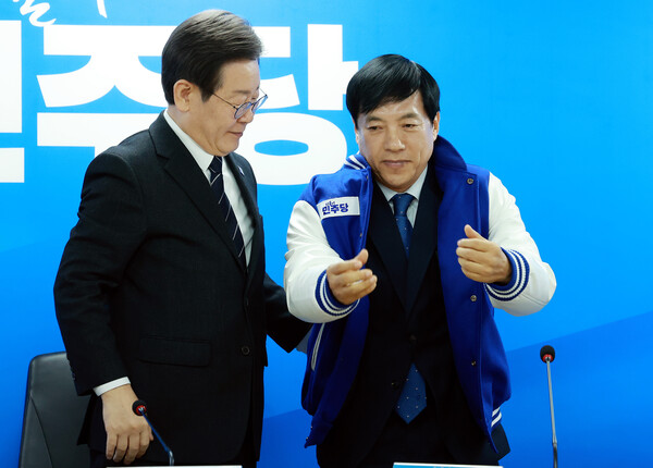 이재명 더불어민주당 대표가 2월 23일 서울 영등포구 중앙당사에서 열린 인재영입식에서 이성윤 전 서울중앙지검장에게 당 점퍼를 입혀주고 있다. photo 뉴시스