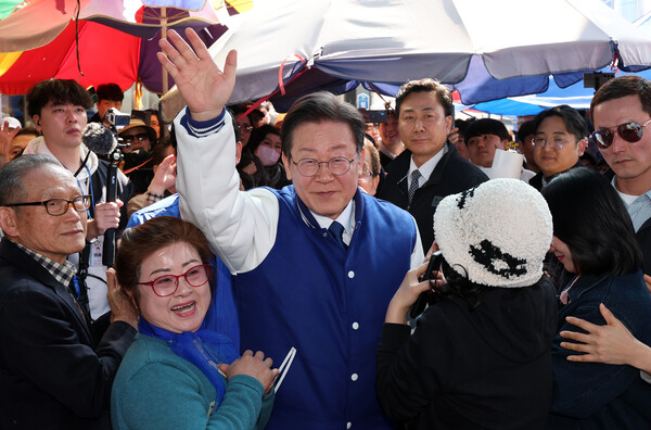 더불어민주당 상임공동선거대책위원장인 이재명 당 대표가 14일 세종시 조치원읍 전통시장을 방문, 시민들에게 손을 들어 인사하고 있다. photo 뉴시스
