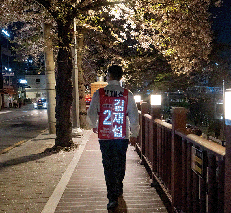 지난 4월 9일 마지막 유세 일정으로 우이천을 찾은 김재섭 후보. LED 조끼를 입고 벚꽃길을 걷고 있다. photo 임화승 영상미디어 기자