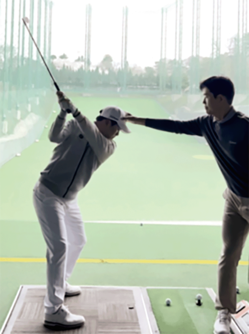 이시우 코치와 머리를 잡아 놓고 스윙 연습을 하는 김민규 프로. photo 민학수
