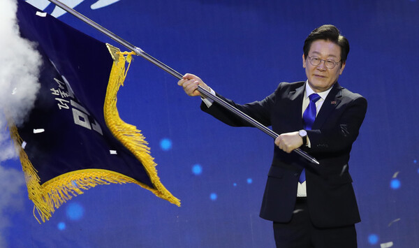 이재명 더불어민주당 신임 대표가 18일 서울 송파구 KSPO DOME(올림픽체조경기장)에서 열린 더불어민주당 제1차 정기전국당원대회에서 대표 선출 후 당기를 이양받아 흔들고 있다. photo 뉴시스