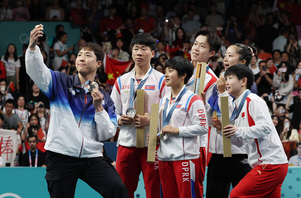 임종훈과 신유빈이 지난달 30일 프랑스 파리 사우스 파리 아레나에서 열린 2024 파리 올림픽 탁구 혼합복식 시상식에서 동메달을 목에 걸고 금메달을 획득한 중국의 왕추친-쑨잉사, 은메달을 획득한 북한 리정식-김금용과 삼성 Z 플립6로 기념촬영을 하고 있다. photo 뉴시스