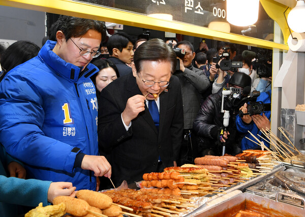 이재명 더불어민주당 대표(오른쪽)와 채현일 당시 영등포갑 국회의원 예비후보가 총선 유세 중인 지난 3월 5일 오후 서울 영등포 뉴타운 지하쇼핑몰 인근 분식집에서 떡볶이를 먹고 있다 photo 뉴시스