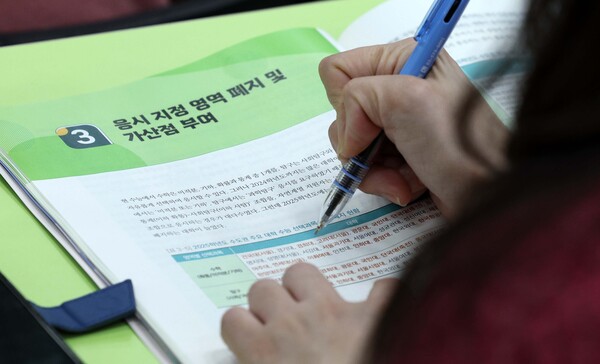 지난 16일 서울 강남구 강남하이퍼학원 본원에서 열린 2025 수능 가채점 설명회를 찾은 학부모들이 자료를 살펴보고 있다. photo 뉴시스