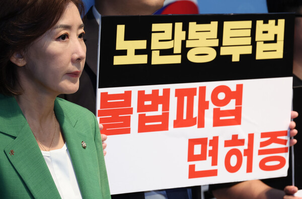 나경원 국민의힘 의원과 노동개혁청년행동 회원들이 지난 12일 서울 여의도 국회 소통관에서 열린 노란봉투법 찬반 여론조사 결과 발표 및 즉각 폐기를 촉구하는 기자회견에서 손피켓을 들고 있다. photo 뉴시스
