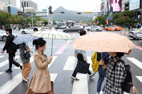 14일 오전 서울 종로구 세종대로 사거리에서 우산을 든 시민들이 이동하고 있다. photo 뉴시스