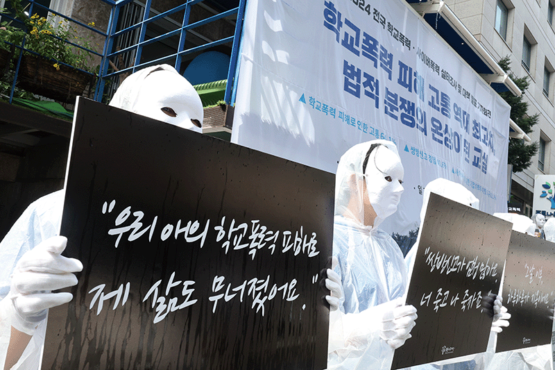 푸른나무재단 직원들이 2024년 7월 24일 서울 서초구 푸른나무재단에서 열린 전국 학교폭력·사이버폭력 실태조사 발표 기자회견에서 학교폭력을 멈출 것을 촉구하는 퍼포먼스를 하고 있다. photo 뉴스1